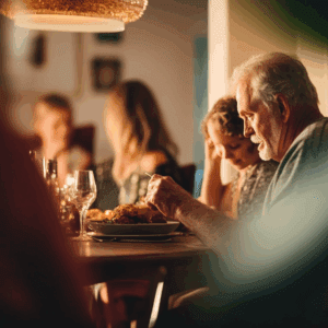 A man eating dinner at the table with his family. Why older adults should be involved in their own care.
